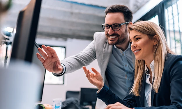 Ein IT-Mitarbeiter bedient in einem Serverraum ein Laptop