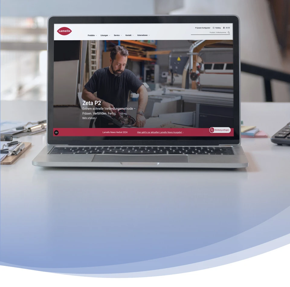 Un ordinateur portable déplié affiche le site web de Lamello à l'écran.
